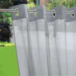 Voilage gris extérieur avec œillets métalliques pour une fixation solide sur une tringle de jardin.