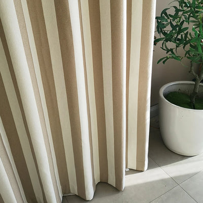 Voilage tamisant à rayures verticales beige et blanc, installé devant une fenêtre avec un pot de plante verte en céramique blanche