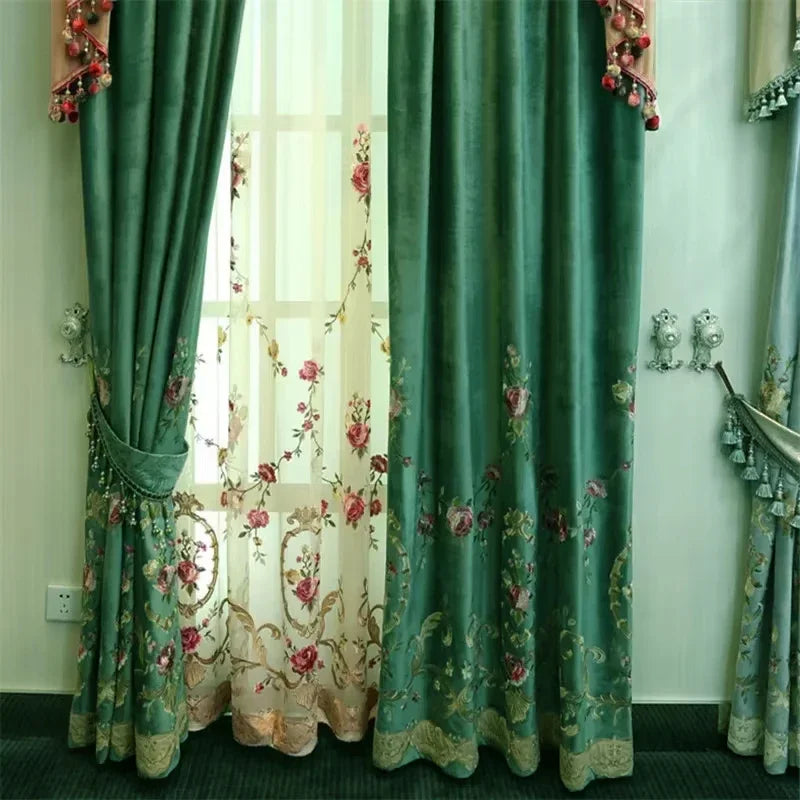Rideaux verts bouteille ouverts, dévoilant un voilage transparent blanc brodé de fleurs roses.