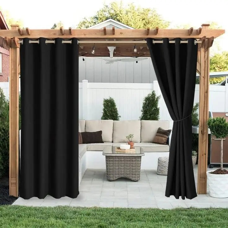 Rideaux noirs occultants installés sur une tonnelle en bois, offrant intimité et protection contre les rayons UV dans un coin salon de jardin chaleureux.