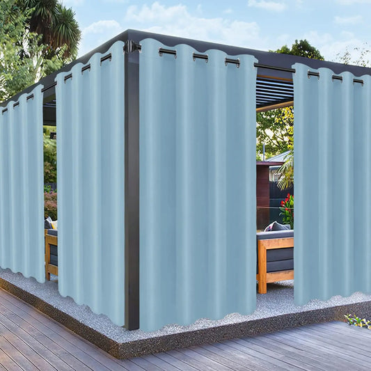 Vue d'une pergola moderne habillée de rideaux imperméables bleu ciel, parfaits pour protéger du soleil et du vent tout en créant une ambiance élégante.