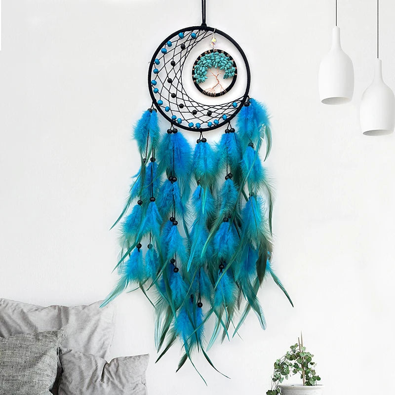 Une suspension décorative aux plumes bleu et vert, avec des motifs géométriques et un pendentif en forme d'arbre de vie, créant une ambiance bohème et apaisante.