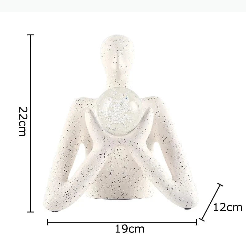 statue décorative personnage humain sphère transparente motifs internes neige cristaux blanc taches noires.texture granuleuse
