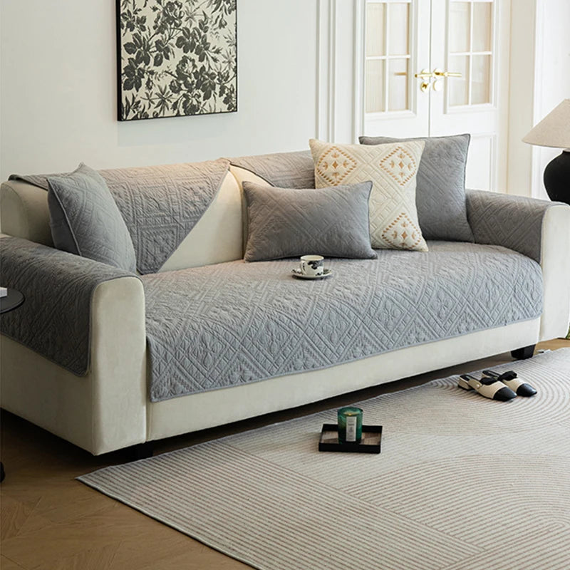 Un canapé gris confortable et élégant, rehaussé de coussins décoratifs, dans un intérieur lumineux et moderne.