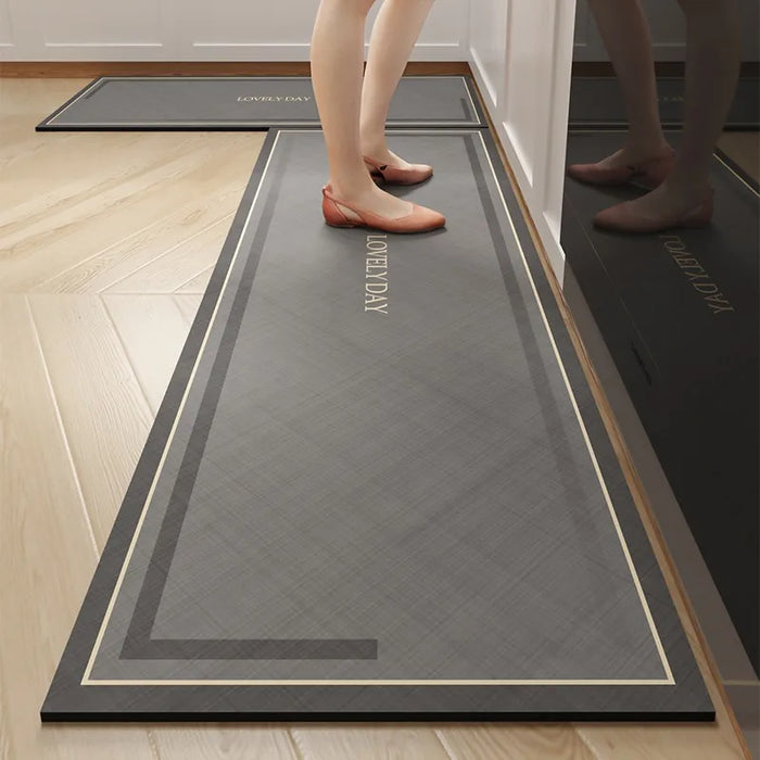 Tapis d'entrée gris avec motif géométrique et inscription, sur lequel se trouvent des pieds de femme portant des chaussures rouges.