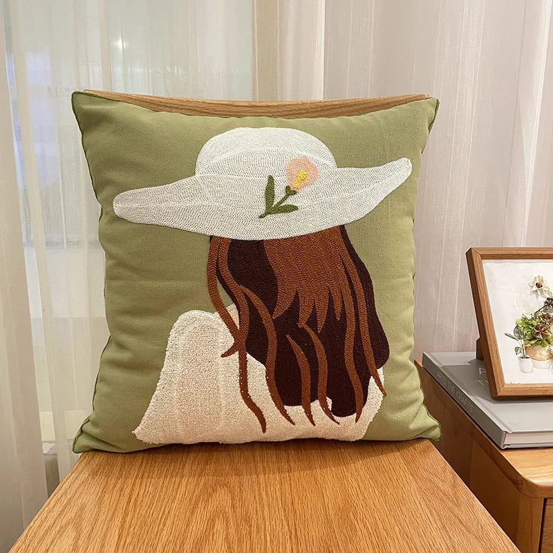 Coussin décoratif vert avec un motif appliqué d'une femme portant un chapeau de soleil.