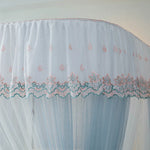 Rideau décoratif en dentelle bleu clair avec des motifs floraux délicats.