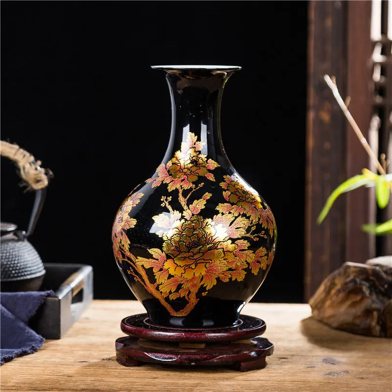 Un vase noir décoré de motifs de pivoines dorées en fleurs sur un support en bois, créant une élégante pièce de décoration dans un intérieur japonais traditionnel.