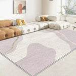 Le tapis aux motifs abstraits dans les tons beiges et crème crée une ambiance élégante et sereine dans ce salon contemporain.