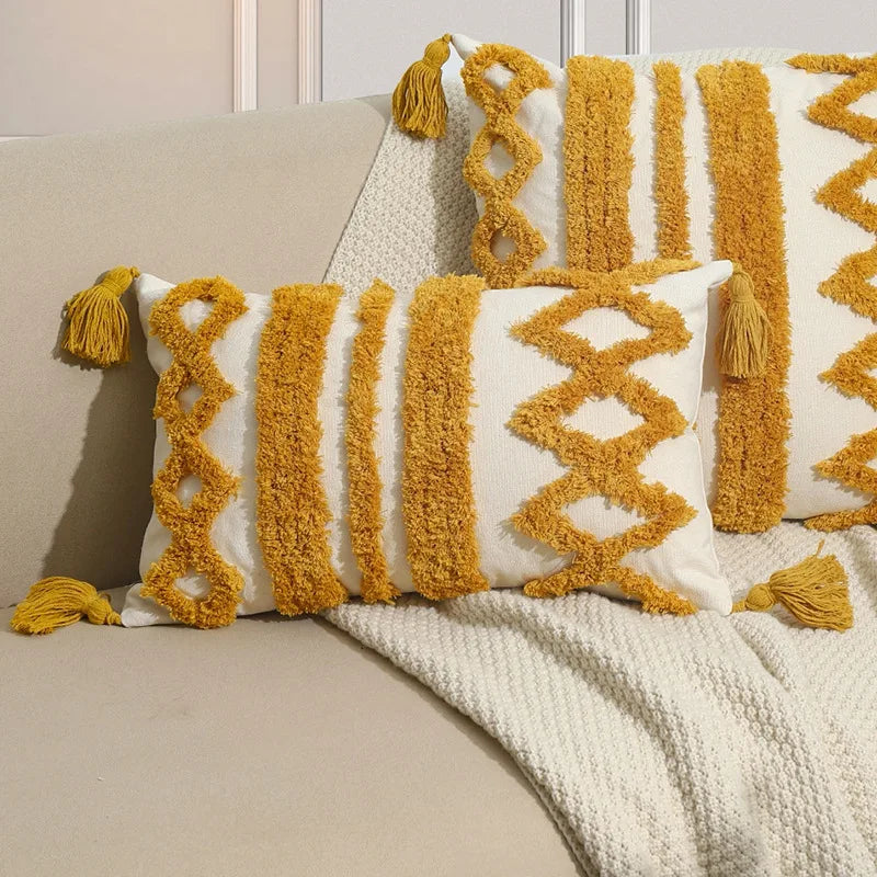 Coussin décoratif avec motifs géométriques en couleur jaune moutarde sur fond blanc.