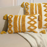 Coussin décoratif avec motifs géométriques en couleur jaune moutarde sur fond blanc.