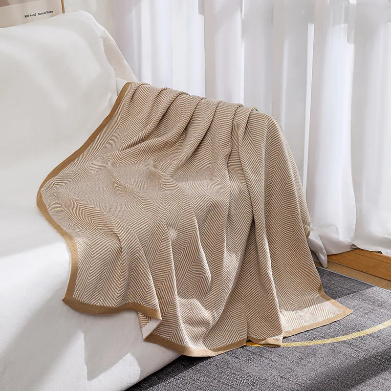 Une couverture en laine beige avec des motifs en zigzag apporte une touche de confort et de style à l'intérieur.