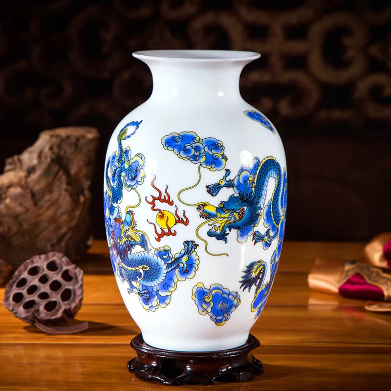 Vase en porcelaine blanche décoré de motifs de dragons et de fleurs stylisées dans des tons de bleu et rouge sur un fond sombre.