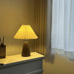 lampe table moderne abat jour plissé tissu brun base bois foncée éclairage chambre coucher