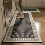 Un tapis noir et blanc avec un motif de lignes et de points décorés sur le sol de la cuisine.