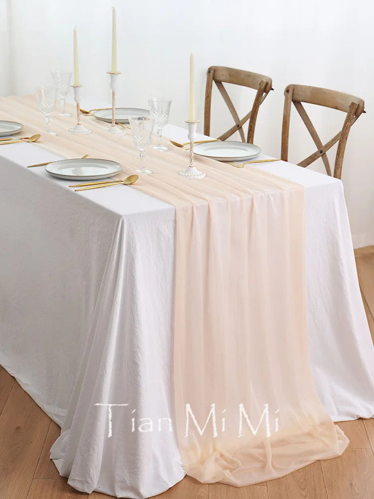 Une table élégante avec une nappe blanche et des accents dorés, entourée de chaises en bois sculptées, créant une ambiance chaleureuse et raffinée.