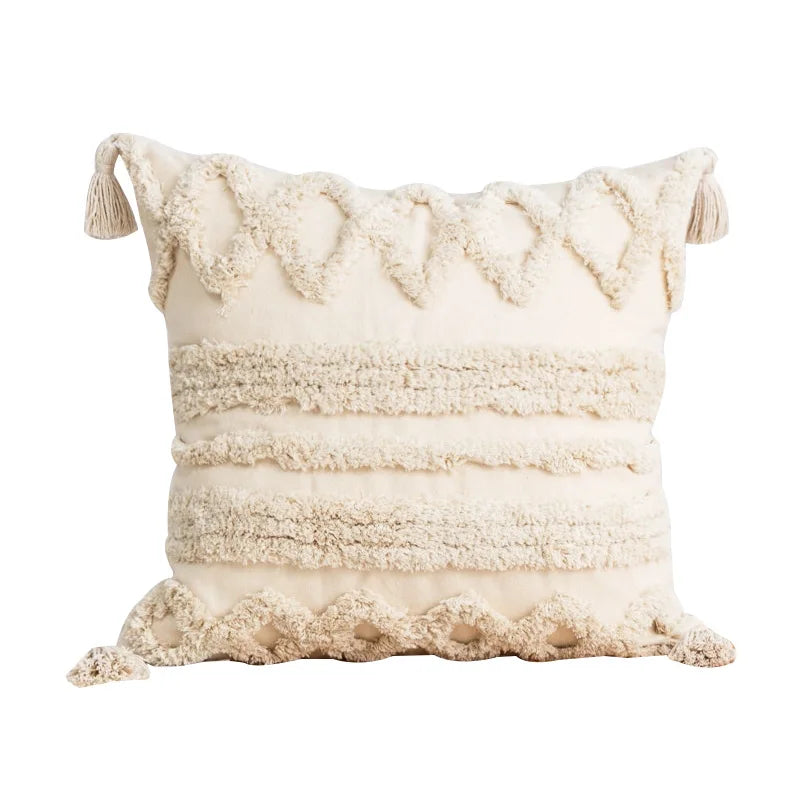 Ce coussin moelleux et texturé avec des franges et des pompons offre une touche de douceur et de chaleur à votre espace de vie.