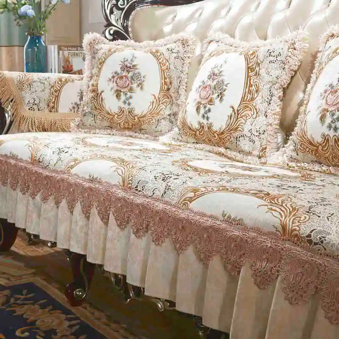 Élégant canapé d'angle capitonné beige et doré avec des motifs floraux, des bordures ornées et des coussins décoratifs.