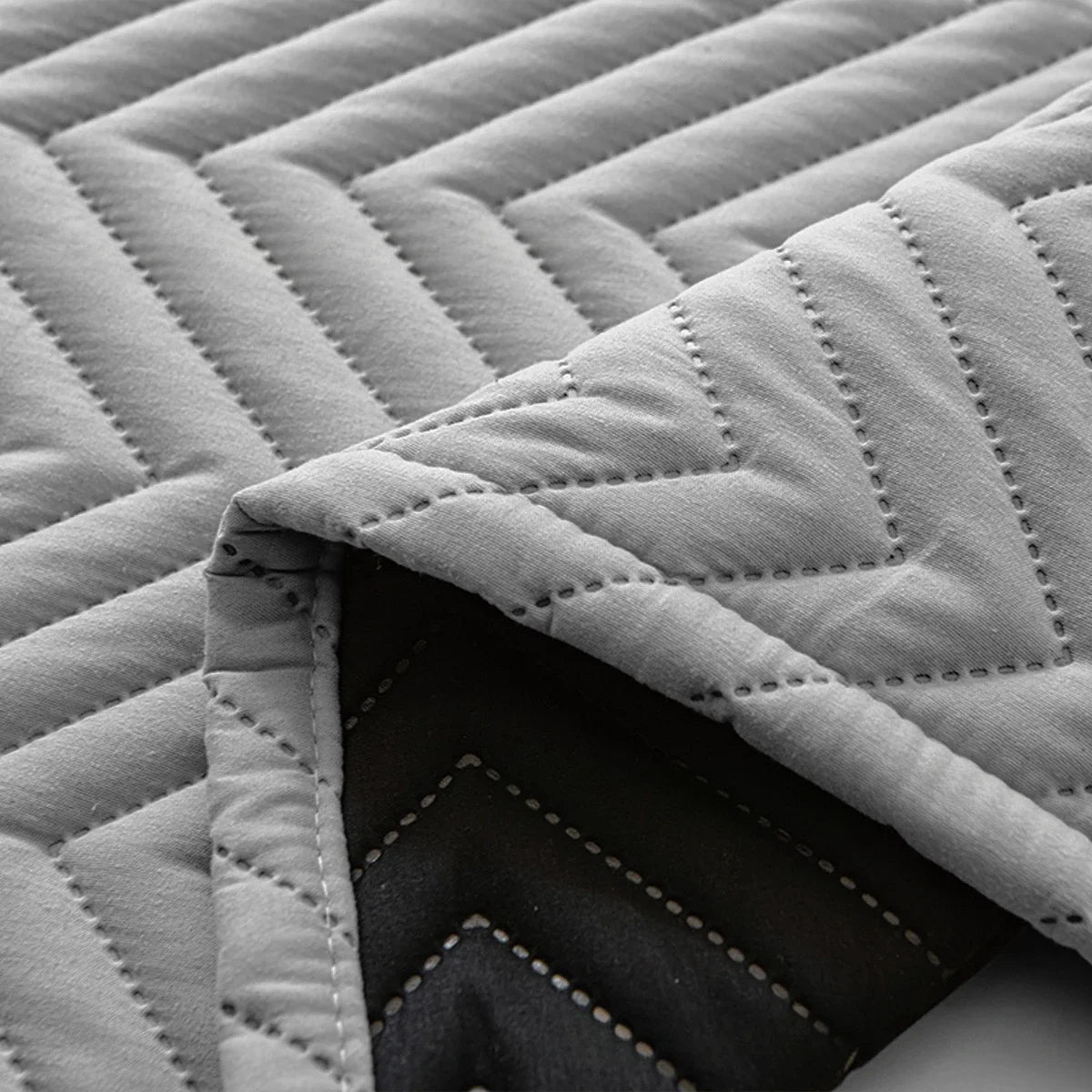 Couverture matelassée grise avec motif en chevrons, idéale pour ajouter confort et style à tout intérieur moderne. Parfaite pour le salon ou la chambre, elle offre une touche élégante tout en restant fonctionnelle et facile à entretenir.