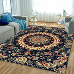Un tapis de sol orné de motifs floraux colorés et détaillés sur un fond noir, créant une atmosphère chaleureuse et accueillante dans ce salon lumineux.