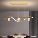 suspension lumineuse moderne or noir courbes élégantes contemporain chaînes suspendues trois sphères luminescentes barre