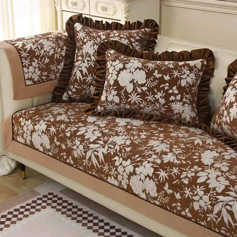 Un canapé élégant, recouvert d'un motif floral délicat en nuances de brun, crée une atmosphère chaleureuse et invitante dans cette pièce.