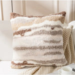Coussin douillet aux rayures beiges et blanches, créant une ambiance confortable et cocooning dans le salon.
