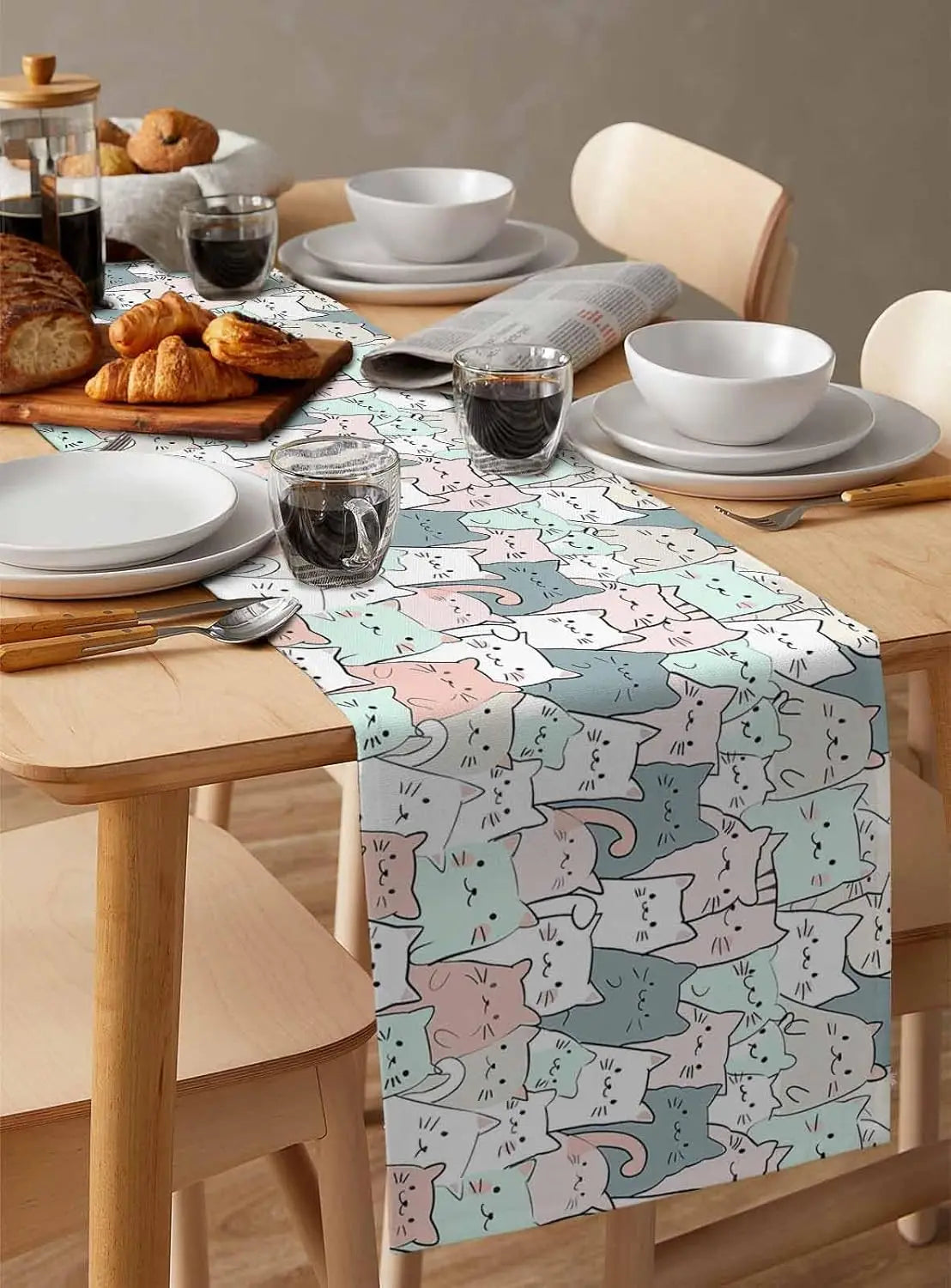 Une belle table de petit-déjeuner avec de délicieux croissants, des tasses de café et une nappe à motif décoratif.