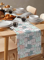 Une belle table de petit-déjeuner avec de délicieux croissants, des tasses de café et une nappe à motif décoratif.
