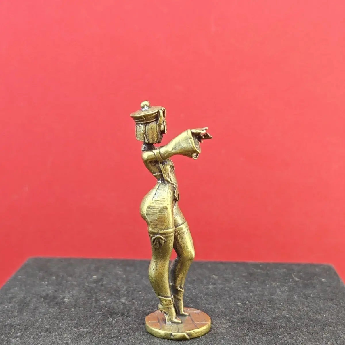 figurine decorative art deco geometrique dorée main trompette chapeau militaire base noire fond rouge