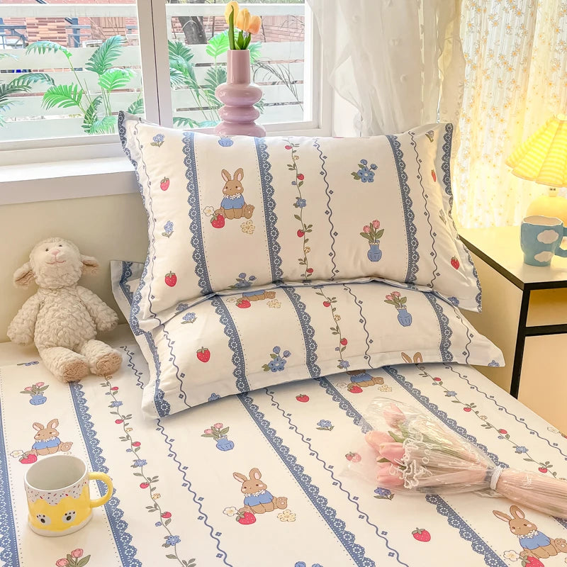 Des coussins et des housses de couette de lit d'enfant décorés de motifs de lapin et de fleurs.