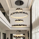 chandelier suspendu moderne plusieurs niveaux anneaux cristal transparents noir doré