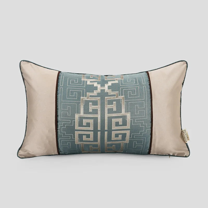 Coussin décoratif rectangulaire en tons de gris et beige avec un motif géométrique complexe.