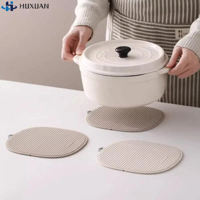 Dessous de plat en silicone noir pliable sur une table en bois