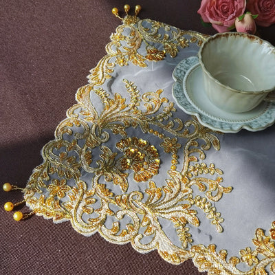 Set de table doré brodé de perles sur une table décorée