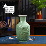 Vase en céramique de forme élancée avec un motif de nuages sculptés en relief sur un fond vert pâle.