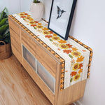 Un meuble en bois avec un chemin de table fleuri, décoré d'un cadre photo et d'une plante en pot.