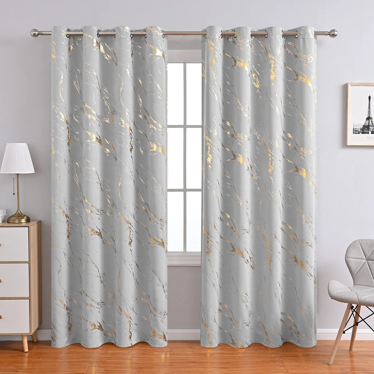 Rideaux occultants gris clair raffinés, ornés d'un motif marbré doré subtil, installés sur une tringle argentée, dans un intérieur moderne et lumineux.