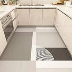 Cette image montre une cuisine moderne avec des comptoirs en pierre de granit blanc et des armoires beige, ainsi qu'un motif graphique en noir et blanc sur le sol en carrelage.