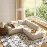 canapé d'angle moderne beige clair uni confortable salon minimaliste inclusion coussins tapis