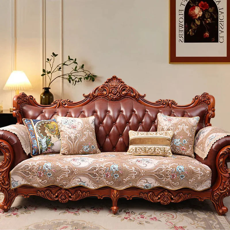 Un canapé vintage en bois sculpté avec des coussins fleuris, créant une atmosphère chaleureuse et élégante dans la pièce.