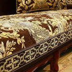 Une chaise en bois ornée de détails ornementaux dorés et de motifs floraux élégants.