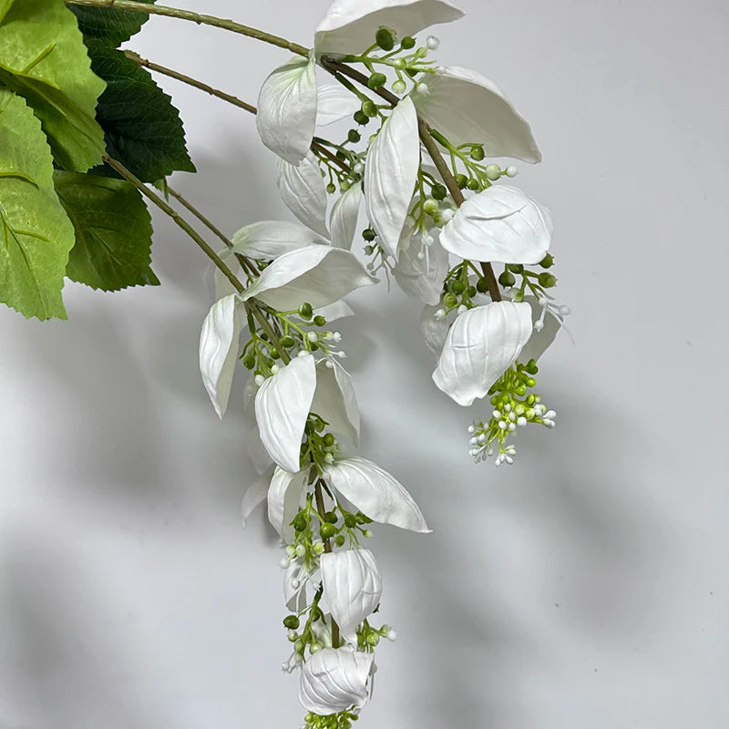 branche artificielle fleurs naturelles extérieur accrochées blanc vert feuilles larges minimaliste