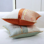 Ce coussin de canapé coloré et décoratif présente des motifs géométriques et des bordures dorées, offrant ainsi une touche de style et d'élégance à l'espace.