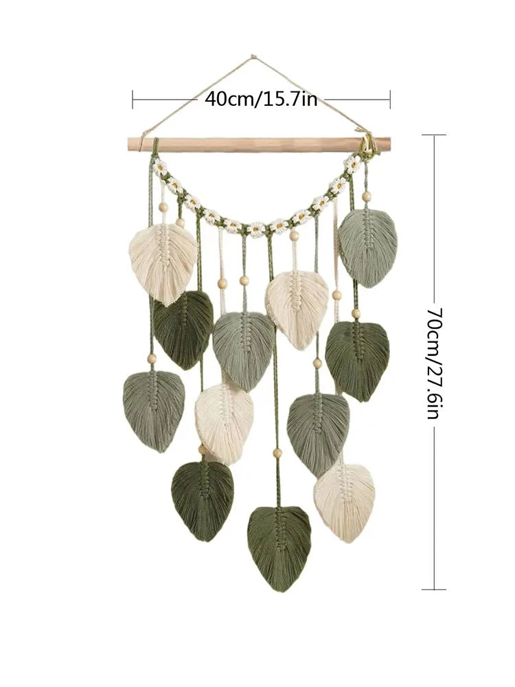 Suspension murale décorative suspendue avec des feuilles en macramé et des perles en bois dans des tons naturels.