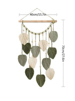 Suspension murale décorative suspendue avec des feuilles en macramé et des perles en bois dans des tons naturels.