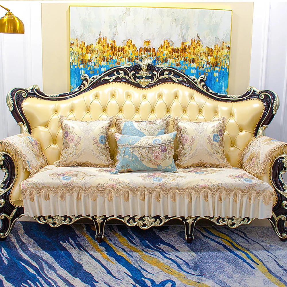 Un canapé baroque en cuir doré avec des coussins ornés de motifs floraux, surmonté d'une toile abstraite aux teintes chatoyantes, créant une atmosphère luxueuse et raffinée.