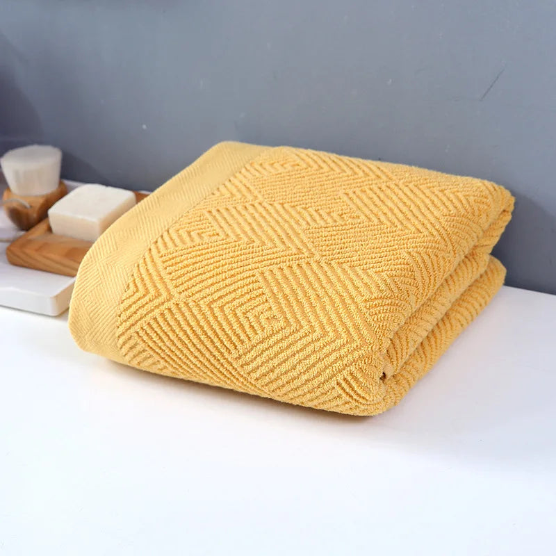Une serviette de bain jaune moutarde avec un motif géométrique élégant, parfaite pour une salle de bain design.