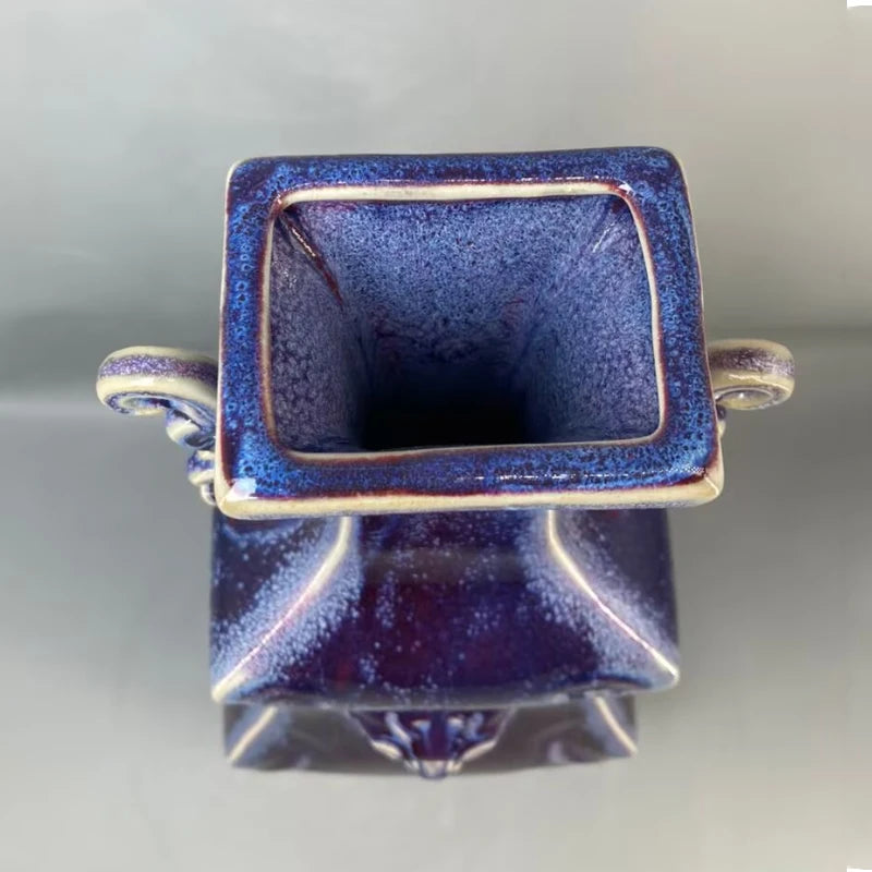 Petit vase cubique en céramique bleue avec décoration dorée.
