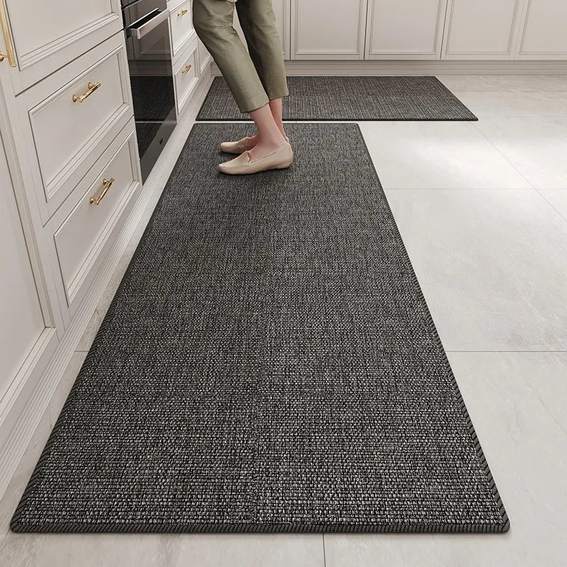 Tapis de couleur grise texturé dans un couloir de cuisine avec des pieds nus.